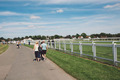 People walking on shore against sky