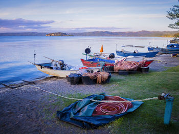 Boat moored on shore against sky