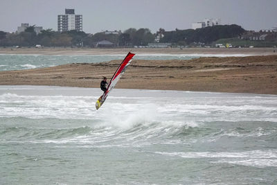 Man surfing in sea against sky