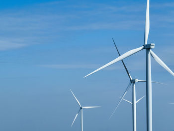 Low angle view of windmill against blue sky