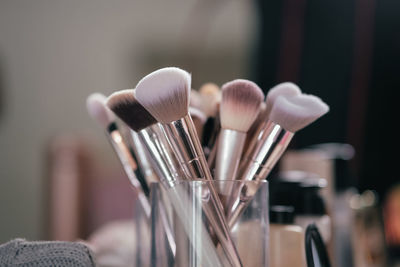 Close-up of make-up brushes in container on table