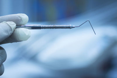 Cropped hand of dentist holding dental equipment