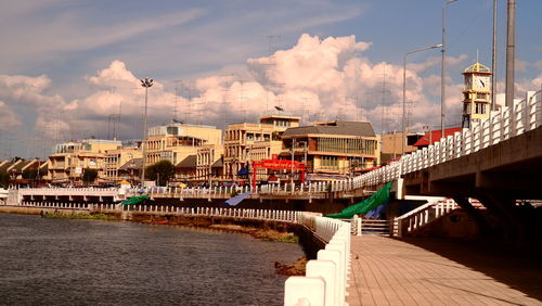 Bridge over river in city against sky