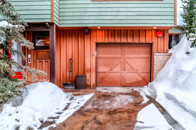 Snow covered house by building