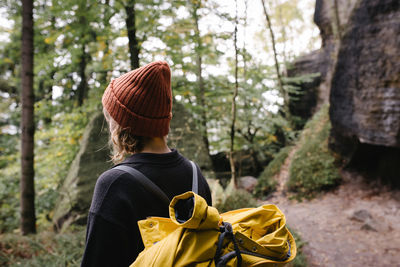 Rear view of young woman walking in forest