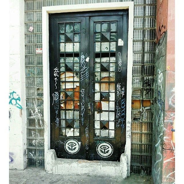 architecture, building exterior, built structure, window, closed, door, building, old, entrance, day, abandoned, wall - building feature, outdoors, city, metal, brick wall, gate, no people, graffiti, house