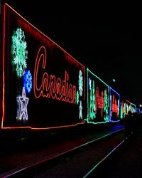 Illuminated text against clear sky at night