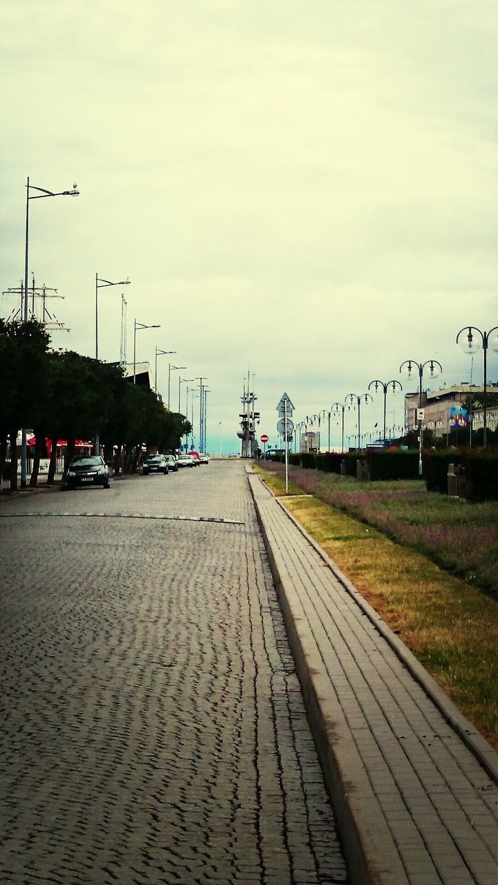 sky, building exterior, built structure, architecture, street light, the way forward, transportation, cloud - sky, street, empty, road, cloudy, day, outdoors, city, no people, overcast, electricity pylon, cloud, diminishing perspective