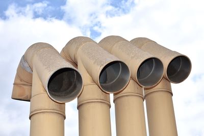 Low angle view of pipes against sky