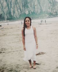 Portrait of smiling young woman standing on beach