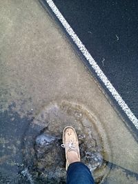 Feet of person stepping in puddle