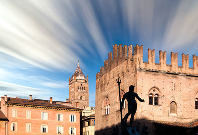 Man standing by historic building against sky in city