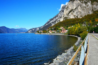 Scenic view of lake and mountains against clear blue sky