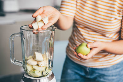 Midsection of woman holding ice cream in glass jar