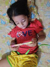 High angle view of girl lying on bed at home