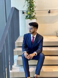 Full length of young man sitting on staircase