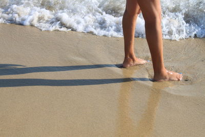 Low section of woman standing on beach