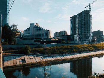 Reflection of buildings in river against sky