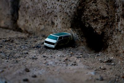 Close-up of abandoned toy car on wall