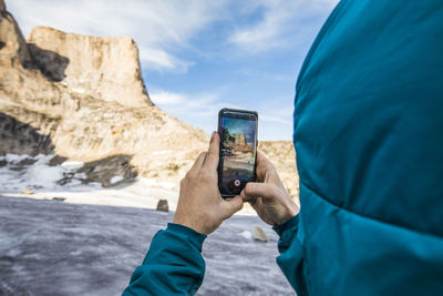 Climber takes photo of asgard mountain with his phone.