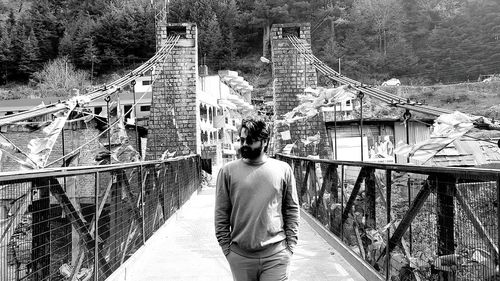 Young man walking on footbridge