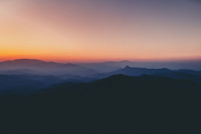 Scenic view of silhouette mountains against sky at sunset