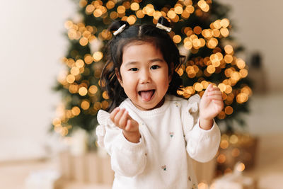 Portrait of an asian emotional little girl child having fun on christmas holiday in decorated house