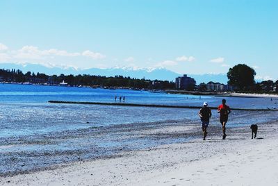People walking on beach against sky