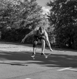 Full length of young woman standing against trees