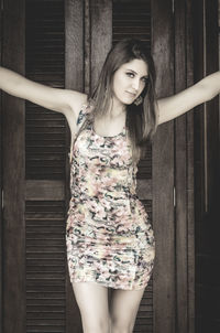 Portrait of young woman standing at home