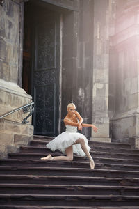 Woman on staircase against building
