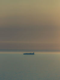 Boat sailing in sea against sky during sunset