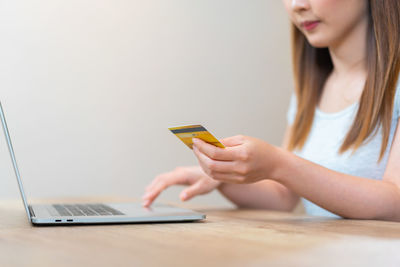 Midsection of woman using mobile phone on table