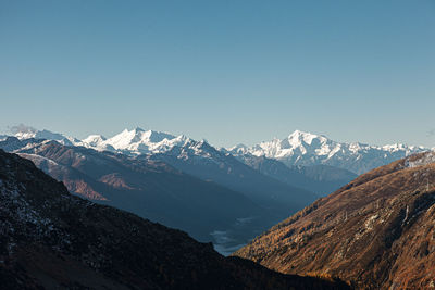 Scenic view of snowcapped mountains against clear sky