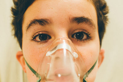 Close-up portrait of boy wearing oxygen mask