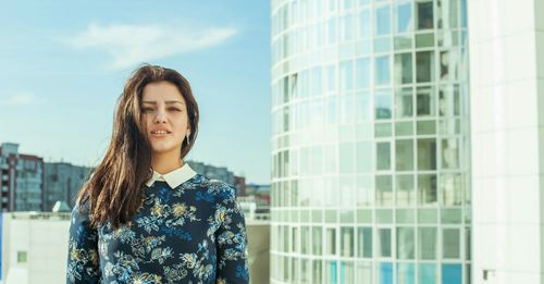 Portrait of smiling woman standing against building