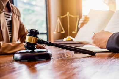 Woman and judge discussing over book at desk