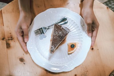 High angle view of woman holding food on table