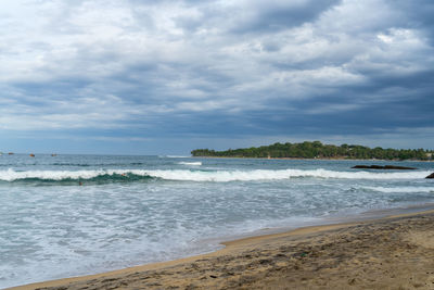 Tropical beach with palm trees. cloudy sky. arugam bay, sri lanka