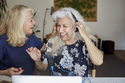 Happy senior women vlogging while sitting at home