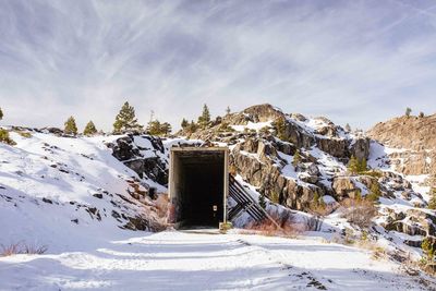 Built structure on snow covered landscape against sky