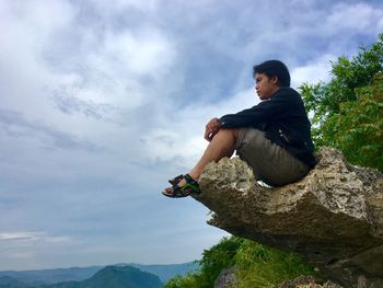 Low angle view of man standing on cliff