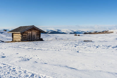 House on snowcapped mountain against sky