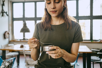 Female entrepreneur preparing coffee using coffee filter at studio