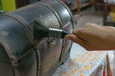 Cropped hand cleaning chest with brush