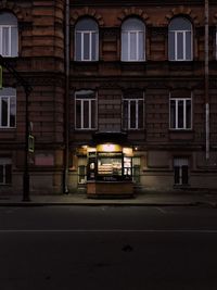 Illuminated building by street at night