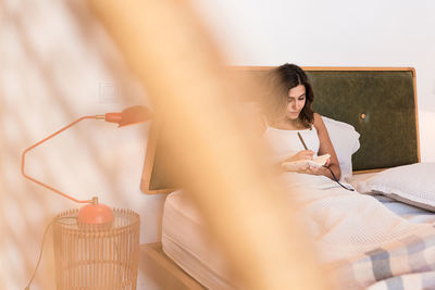 Woman sitting on bed