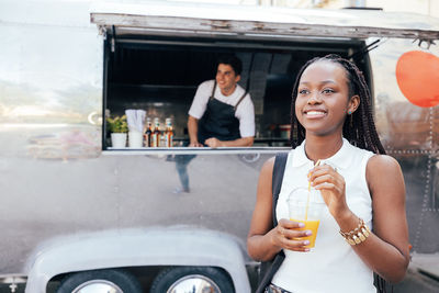 Portrait of smiling young woman sitting in car