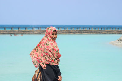 Man standing on beach against clear sky