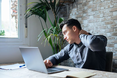 Young businesswoman using laptop at office